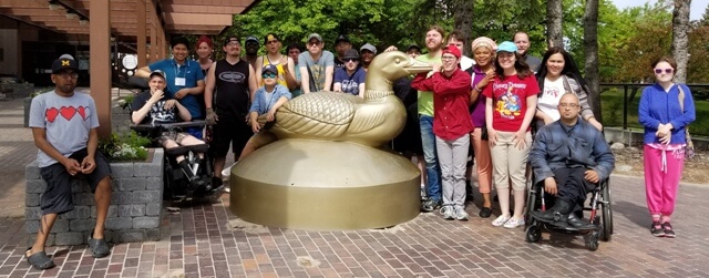 Participants gather round statue of a gold loon at Royal Canadian Mint